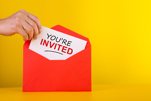 You're Invited Concepts - Hand holding a card with red envelope. photo