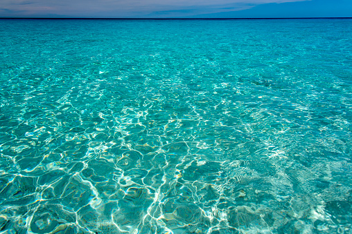 Rays of sunlight reflected on shallow water in a crystal clear Caribbean Sea.