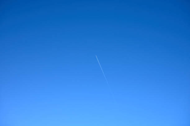 istock plane soaring through the blue sky and leaving a white wake 1297969786