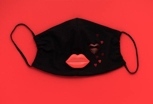 Red heart and lips with medical protective mask on red background, top view, flat lay. Creative Concept love, valentine 'day, healthcare, protection