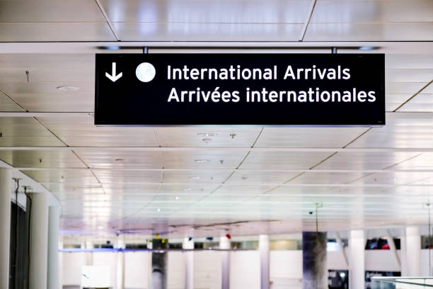 공항 터미널 홀에서 국제선 도착시 영어와 프랑스어로 간판을 지정합니다. 코로나바이러스 변종 확산 및 공동 여행 제한, 가까운 국경 개념으로 영국의 항공편 금지. - airplane commercial airplane airport arrow sign 뉴스 사진 이미지