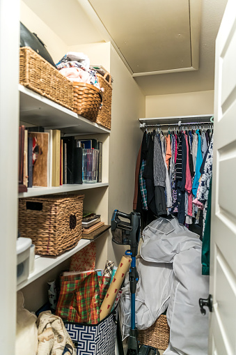 A messy and unorganized walk in closet in a house