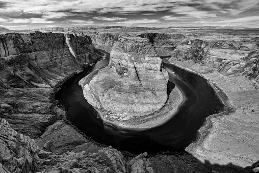 Black and white image of the Horseshoe Bend, an eroded canyon of the Colorado river in the form of a horseshoe.