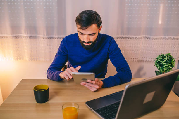 istock Man working with tablet late at night at home 1297977914