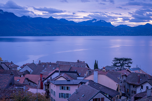Sunset over lake leman and houses with red roofs. Lavaux region, Vaud Canton in Switzerland. Tranquil scene.