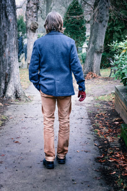 istock back of man in jacket walking outside in park 1297979033