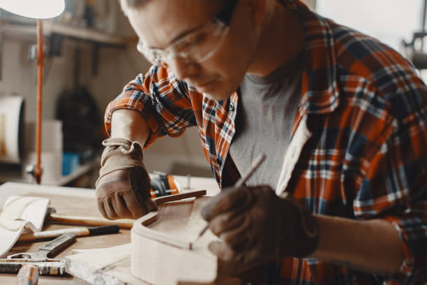 istock Man in the workshop with a wood 1297980644