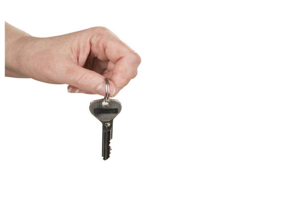 istock Hand is holding a keys for a new house on a white 1297981872