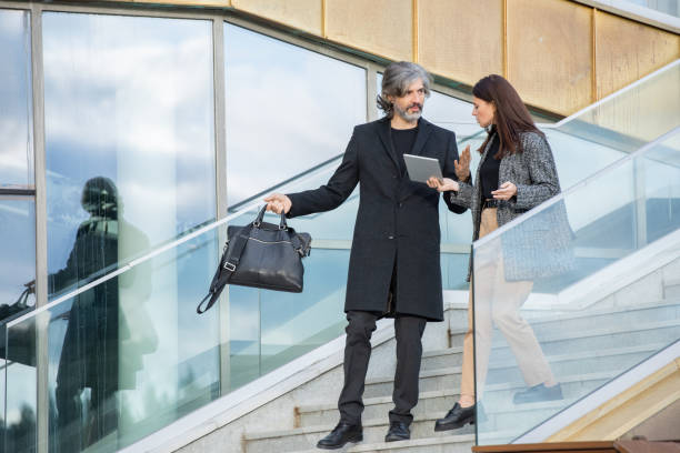 istock Mature businessman and his young female subordinate discussing working points 1297983079