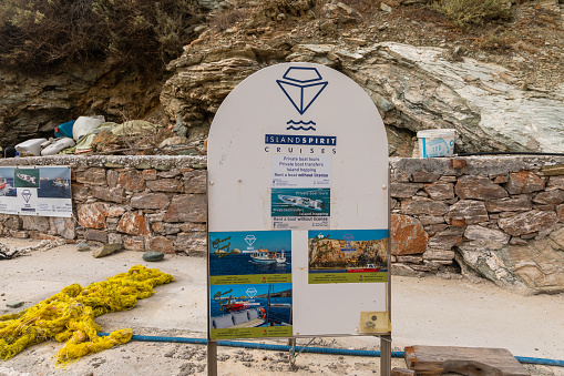 Agkali Beach, Folegandros Island, Greece- 24 September 2020: Advertising for cruises and water sports. Yellow boat mooring line.