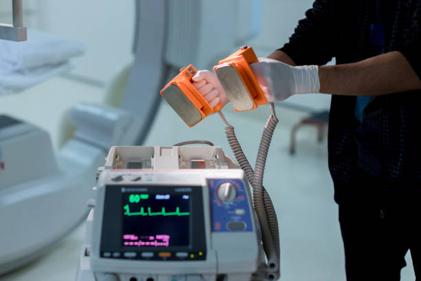 The doctor is giving a defibrillators to save the patient's life in the hospital. stock photo