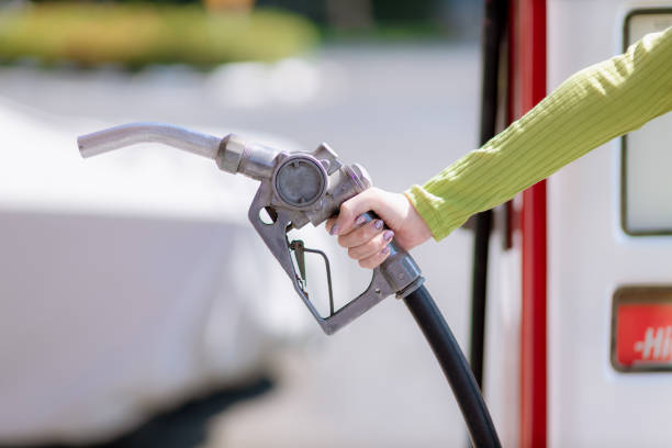 istock Hand holding gas nozzle with one last drop. A man holding a gasoline nozzle. 1297986402