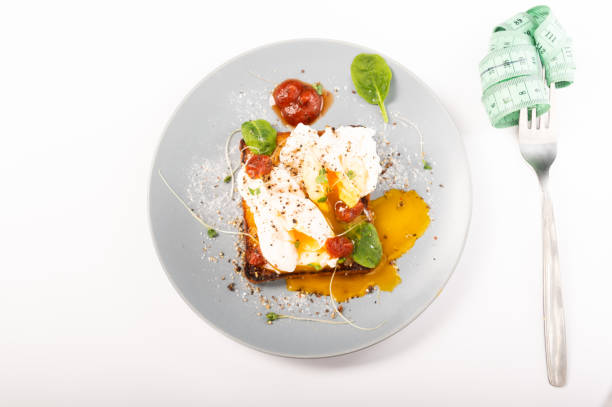 istock Dish and fork with ruler. Diet food and a fork with a ruler. 1297986972