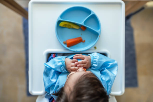 Baby Boy eating his first meal by himself