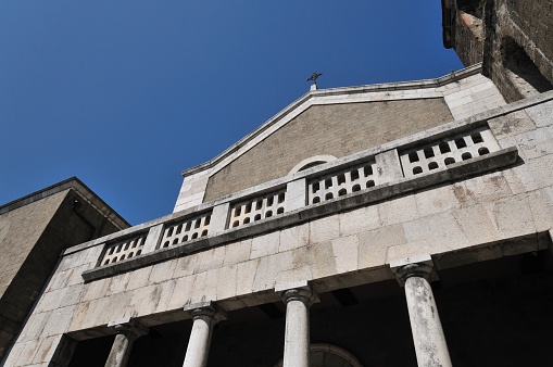 The cathedral, originally dedicated to San Terenziano, was later named after San Clemente. Construction began in 1050 by Bishop Guglielmo, to replace the old cathedral of San Paride ad Fontem, located outside the city walls. The works were completed in 1116 by Bishop Pandulfo. The building has a basilica structure divided into three naves by two rows of columns.  In 1608 it was damaged internally by a fire that almost completely destroyed the cosmates ambo, subsequently recomposed using the remains of the previous one integrated with the marble slabs of a fourteenth-century sepulchral monument already present in the church and positioned on twisted columns, two of which rested  on fountain lions. During the 16th century the Romanesque apse was modified and on that occasion a precious carved wooden choir was built in the presbytery, built in 1539 by the Benedictine Antonio Maria Sertorio.  The choir underwent two restorations, the first in the 17th century and the second in 1957, following the damage suffered during the Second World War.