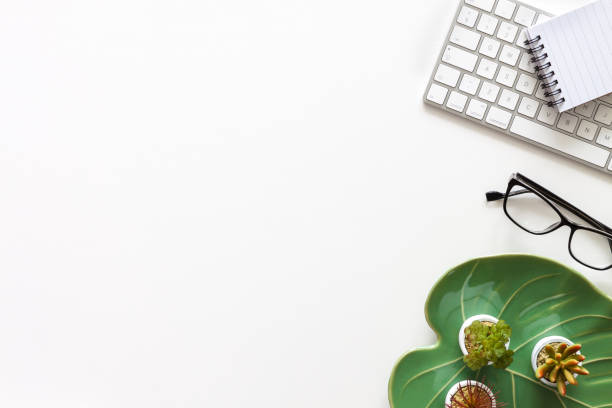 istock White desk with copy space. Monstera leaf ceramic decoration. Computer keyboard and office supplies. 1297990257