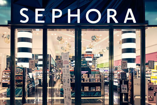 Milan, Italy - 17.12.2020. Sephora logo and showcase of the store at night with christmas decoration. Sephora is makeup, perfume, beauty cosmetics store.