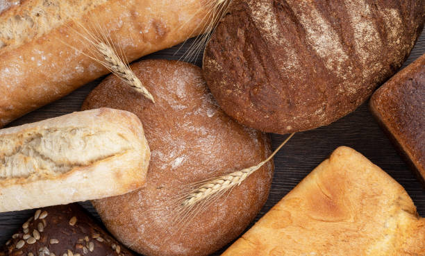 istock Different varieties of wheat and rye bread on a wooden table. 1297994283
