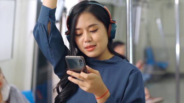 istock Young woman using mobile phone on public train 1297994766