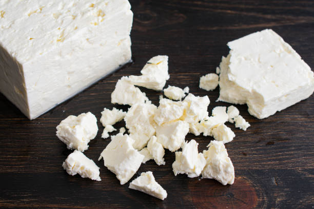 Crumbling a Block of Feta Cheese A block of feta cheese that has been broken into small pieces feta cheese block stock pictures, royalty-free photos & images