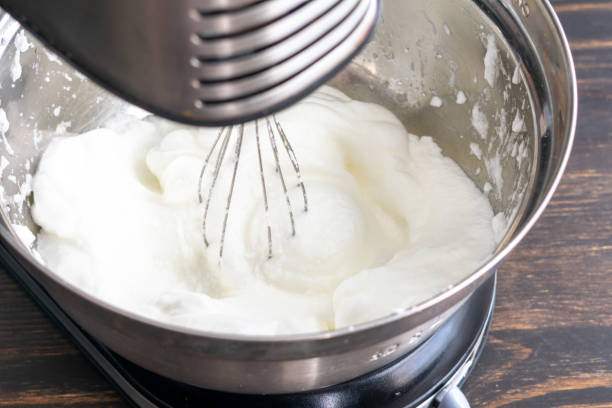 Whisking Egg Whites to Make Meringue Egg whites that have been beaten in a stand mixer until they form stiff peaks meringue stock pictures, royalty-free photos & images