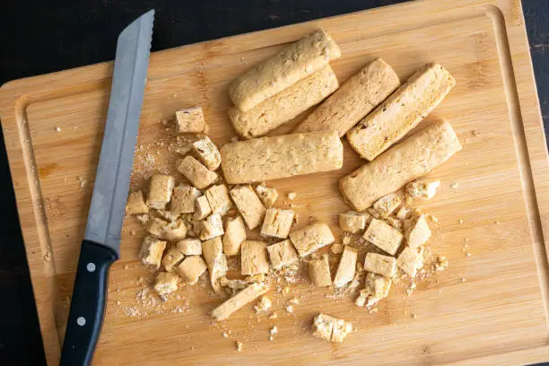 Using a serrated bread knife to cut up almond biscuits
