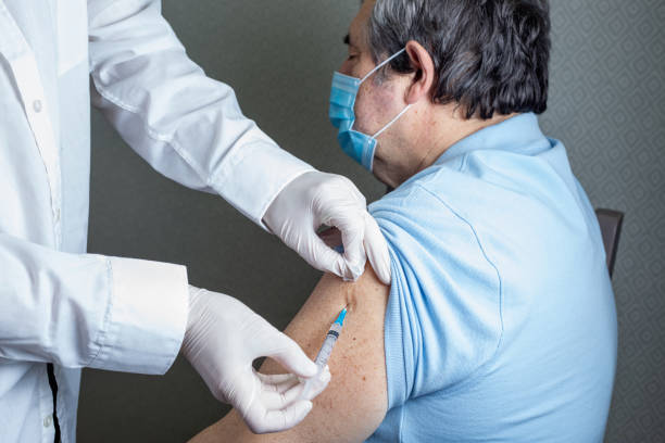 istock Antivirus vaccination for older people in clinic. General practitioner vaccinating an elderly patient against flu, influenza, pneumonia or coronavirus. 1297996002