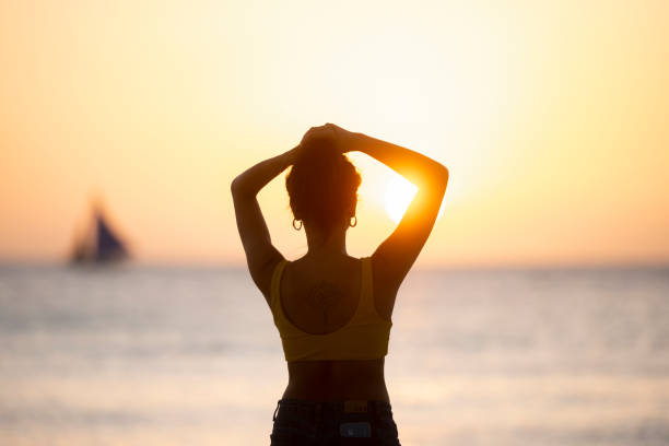 (mise au point sélective) vue renversante de la silhouette d’une fille marchant sur une plage pendant un coucher de soleil beau et romantique. white beach, boracay island, philippines. - people traveling elegance philippines palawan photos et images de collection