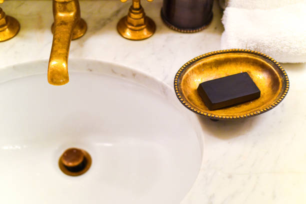 A bar of charcoal soap in soap dish on a bathroom sink