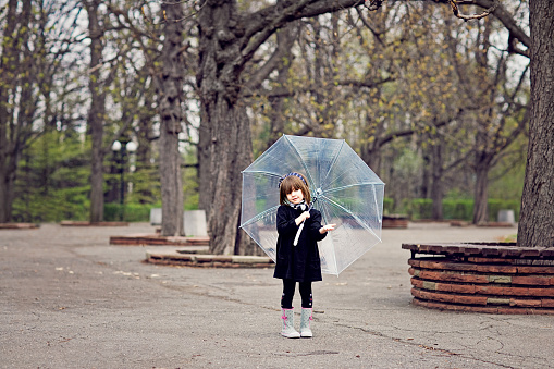 Portrait of little girl hiding from the rain