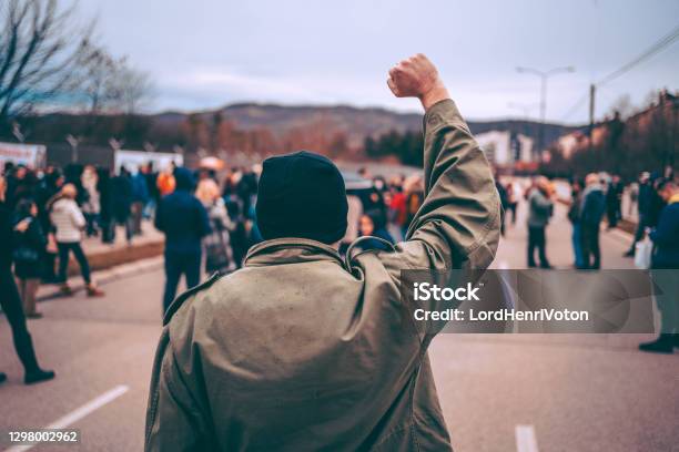 Man Protests In The Street With Raised Fist Stock Photo - Download Image Now - Protest, Anti-racism, Riot