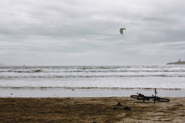 Bicycle lying on the beach with kite