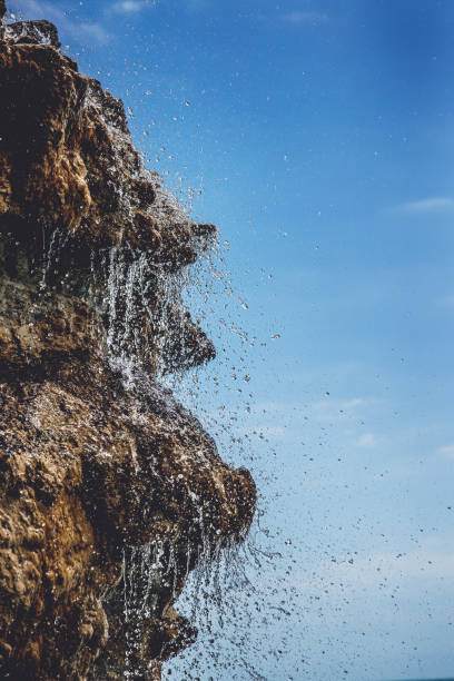 agua pura de manantial, una cascada sobre rocas pintorescas. salpicando un arroyo en las piedras. concepto de ecología. - water waterfall sky seascape fotografías e imágenes de stock