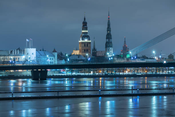 Urban landscape of Old Town Riga with reflections in the river Daugava on a winter evening. Yacht port of Kipsala can be seen in the foreground
