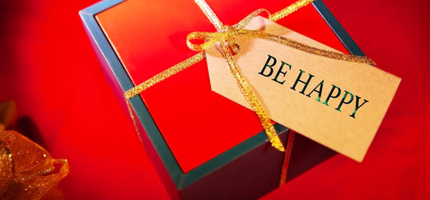 istock Gift box label with text - be happy, red background, view from above. 1298008202