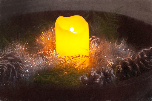 Candle in wood bowl with pine cones