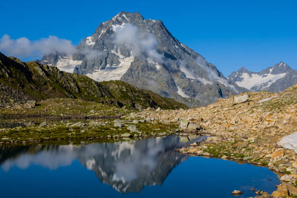 istock mountain valley blue lake and mount peak 1298010808
