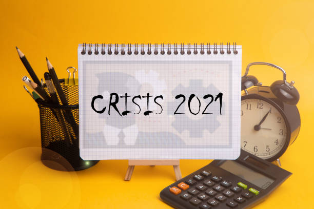 istock CRISIS the word written on the Notepad,yellow background, calculator 1298011414
