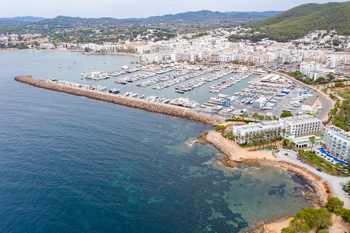 Aerial photo of the beautiful island of Ibiza, Spain in the Balearic islands showing the beach and harbour area by the mediterranean sea in Santa Eularia des Riu on a bright sunny summers day