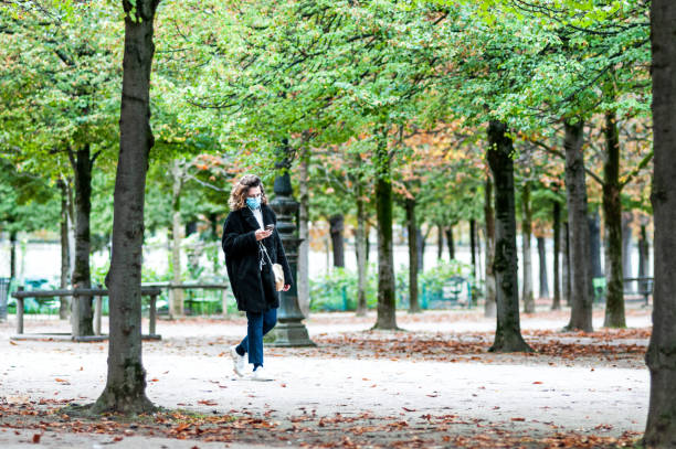 paris: une femme marchant au jardin des tuileries pendant la pandémie covid-19 - jardin luxembourg photos et images de collection