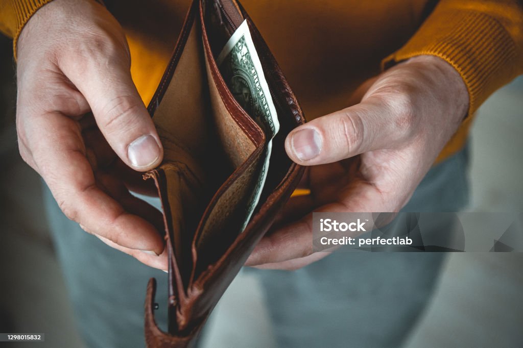 Empty wallet in the hands of a young man An Empty wallet in the hands of a young man Empty Wallet Stock Photo
