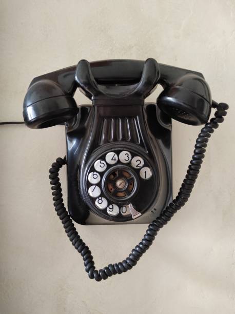 istock Old phone hanging on the wall. Black color. Vintage 1298015833