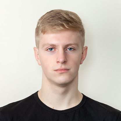 Close up studio portrait of 20 year old blond man in black t-shirt on white background