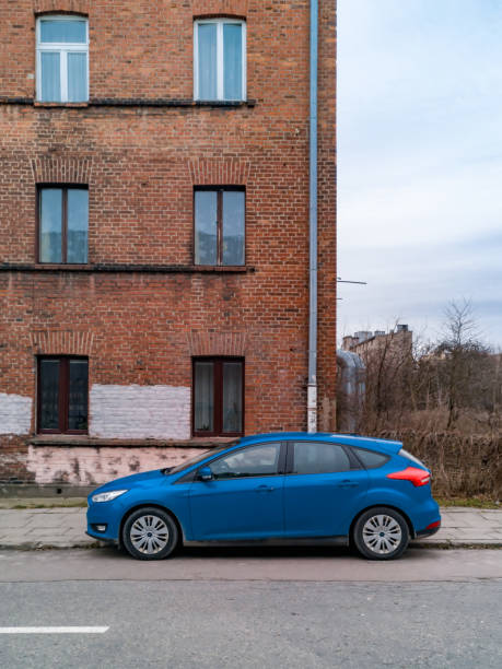 auto blu in piedi di fronte al vecchio edificio in mattoni rossi - ford fiesta foto e immagini stock