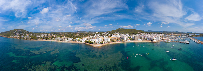 Panoramic high resolution wide aerial photo of the beach front in Ibiza in Spain, showing the coastal Spanish beaches and the Marina Santa Eulalia in the village know as Santa Eulària des Riu