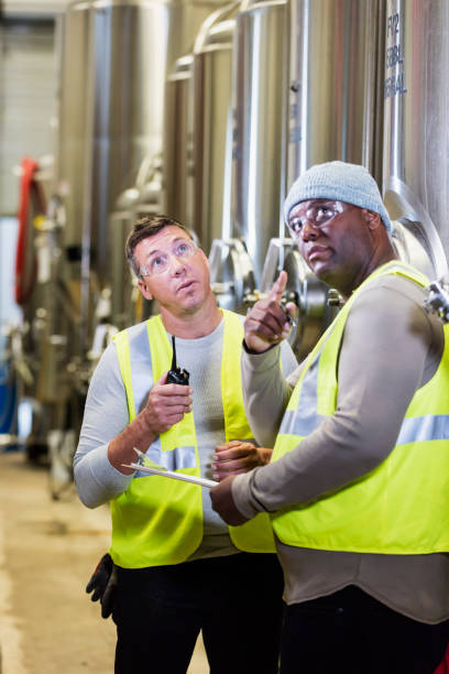 istock Two men working in factory, looking up 1298022743