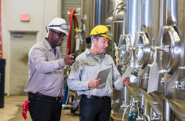 istock Two men working in factory, inspecting storage tank 1298022771