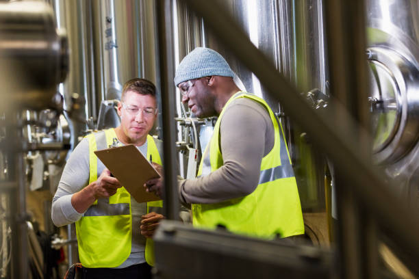istock Two men working in factory, looking at clipboard 1298022788