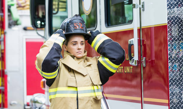 istock Female firefighter putting on helmet 1298023375
