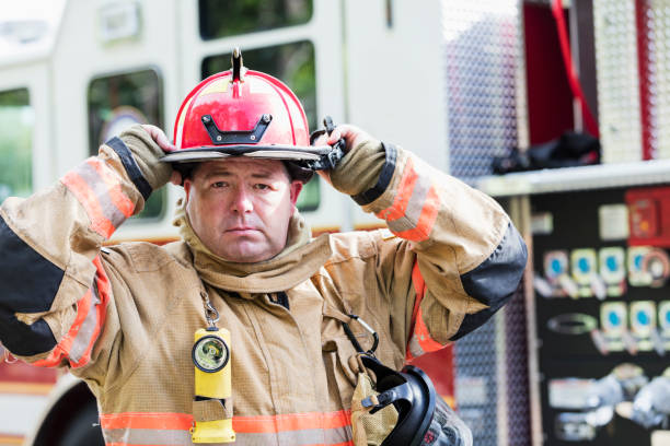 istock Firefighter in fire protection suit putting on helmet 1298023403